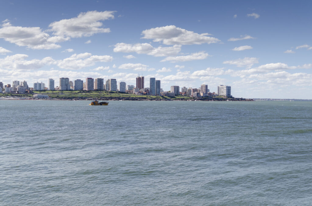 Vista de Mar del Plata desde el mar, con la línea de edificios de la costa y una embarcación